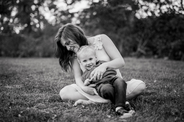 mom and son cuddling and laughing in the grass