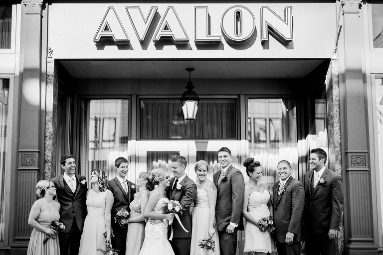 black and white photo of bridal party laughing in front of a downtown Avalon event center